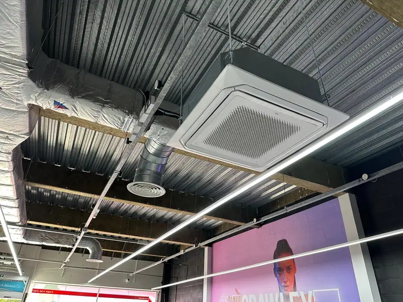 Ceiling cassette and spiral ductwork beneath an exposed metal roof deck