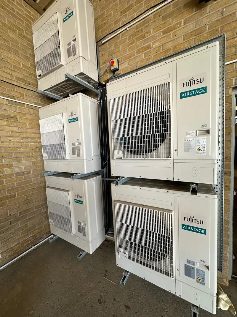Stacked outdoor air conditioning units on wall brackets