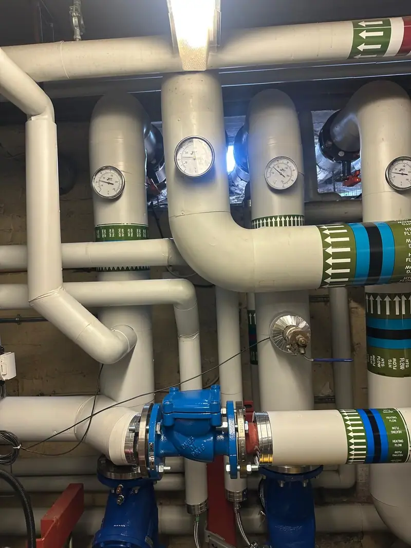 Upgraded plant room pipework with gauges, valves and colour-coded insulation