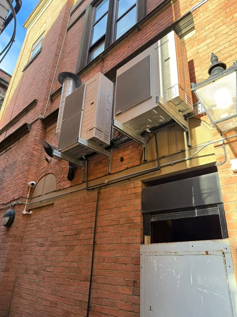 Outdoor heat pump units on a brick wall